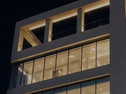 夜、各フロアに明かりの灯ったクリニックの建物