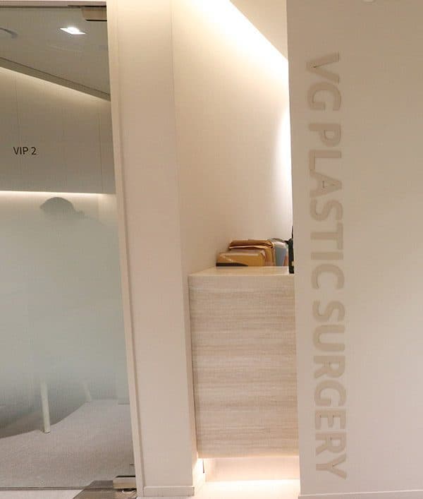 VG PLASTIC SURGERY と刻まれた柱と、すりガラスで仕切られた個室カウンセリングルーム